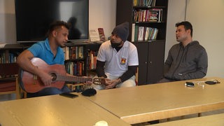 Drei Seeleute aus Kiribati beim gemeinsamen Musizieren im Bremerhavener Seemannshotel