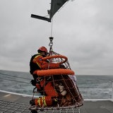 Ein Seenotretter evakuiert eine Person.