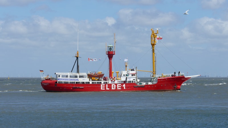 Das Feuerschiff Elbe fährt mit Leucht-Aufbauten auf dem Meer