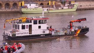 Ein gekentertes Segelboot wird auf der Weser von der Schifffahrtspolizei abtransportiert.