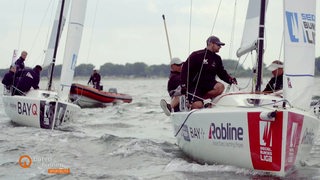 Segelschiffe mit ihrer Besatzung auf dem Wasser.