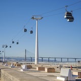 Eine Seilbahn, im Vordergrund eine Brücke mit Sitzgelegenheiten.
