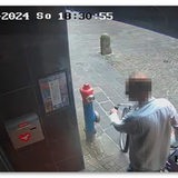 Ein Mann wird von einer Überwachungskamera gefilmt, während er ein Fahrrad schiebt. Kopf ist verpixelt