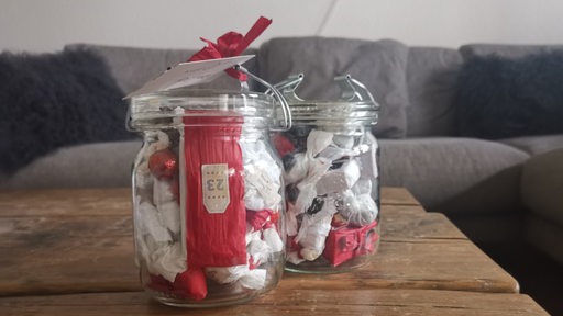 Rot-weiß verpackte, nummerierte Süßigkeiten in zwei Adventskalender-Weckgläsern.