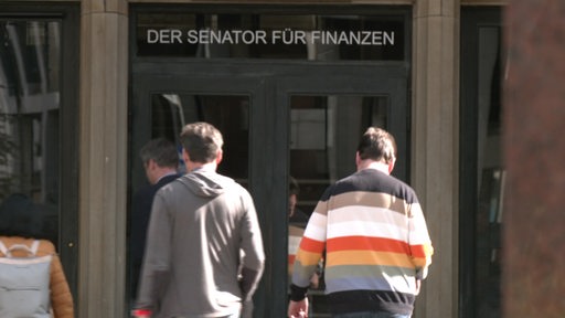 Mehrere Menschen vor dem Gebäude der Senator für Finanzen in Bremen. 
