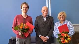 Anna-Katherina Buse (r.) und Julien Sauer (l). wurden von Innensenator Ulrich Mäurer (SPD) für Zivilcourage ausgezeichnet.