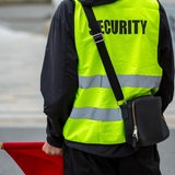 Ein Sicherheitsdienstmitarbeiter hält eine rote Flagge in der Hand.