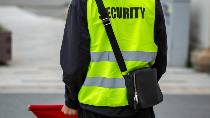 Ein Sicherheitsdienstmitarbeiter hält eine rote Flagge in der Hand.