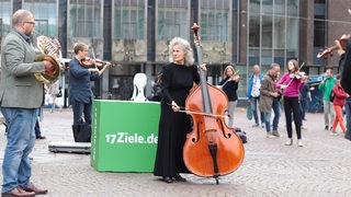 Klassische Orchestermusiker musizieren vor der Bremer Bürgerschaft.