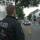 Ein Polizist steht vor einer abgesperrten Straße im Viertel.