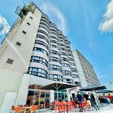 Eine Außenaufnahme des ehemaligen Kellogs-Gebäudes. Vor dem neu-eröffneten Hotel stehen Gäste und Besucher. 