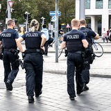 Einsatzkräfte der Polizei laufen über den Bahnhofsvorplatz.