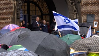 Teilnehmer einer Solidaritätskundgebung für Israel stehen auf dem Bremer Marktplatz