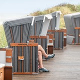 Ein Tourist sitzt bei Regenwetter an einer Strandpromenade in einem Standkorb