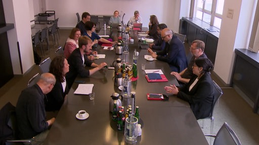 Politikerinnen und Politiker der Grünen und der SPD führen gegenüber an einem Tisch Sondierungsgespräche.