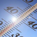 Ein Thermometer zeigt Temperaturen über 35 Grad Celsius an, im Hintergrund blauer Himmel und Sonne