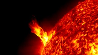 Aus dem glühenden Plasma der Sonnenobfläche schießt eine Flammensäule empor
