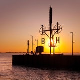 Die Sonne geht hinter einem Signalmast in Bremerhaven auf.