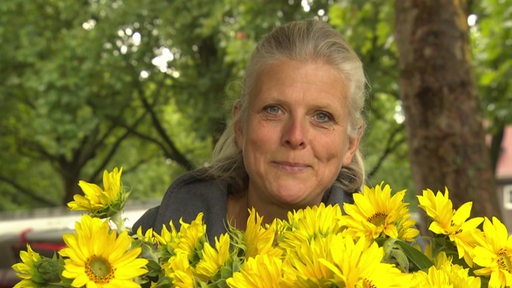 Die Biolandwirtin Ines Meyer vor zahlreichen Sonnenblumen.