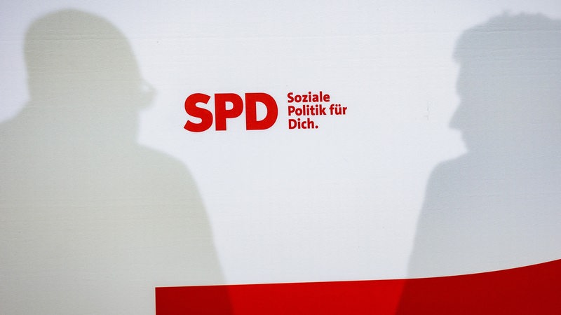 Die Silhouetten von Andreas Bovenschulte und Lars Klingbeil sind auf einer rot-weißen Wand mit SPD-Schriftzug zu sehen.