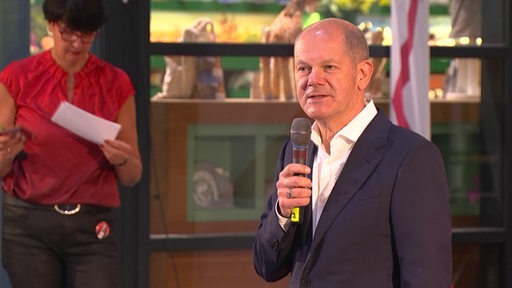 Der Kanzlerkandidat der SPD Olaf Scholz bei einem Wahlkampfauftritt in Bremerhaven. Er steht im Klimahaus auf einer Bühne mit einem Mikrofon in der Hand.