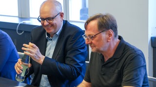Bremens Bürgermeister Andreas Bovenschulte und der SPD-Landeschef Reinhold Wetjen sitzen zu Beginn der Sondierungsgespräche zwischen SPD und Grünen in einem Konferenzraum.