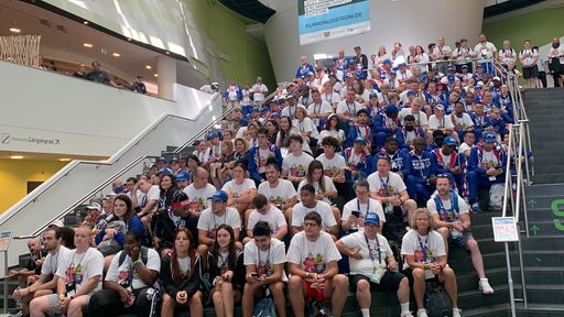 Das US-Teams der Special Olympics sitzen für ein Gruppenfoto auf einer Treppe im Klimahaus Bremerhaven.