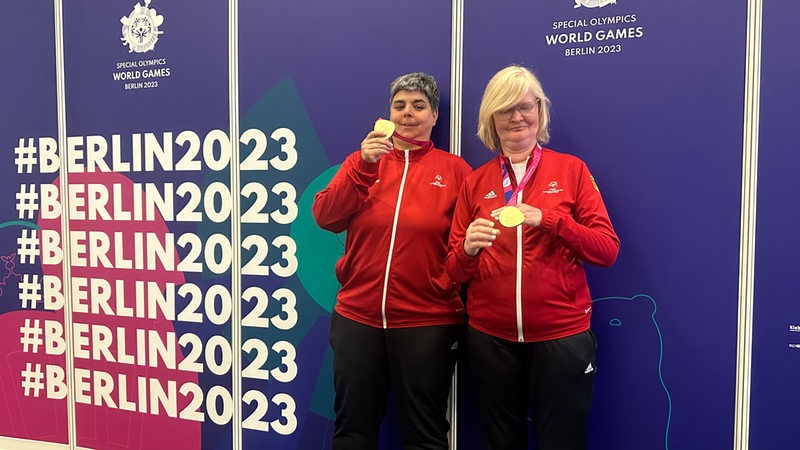 Die Bremer Boccia-Spielerinnen Hanni Kjeldsen Iris Regelin halten ihre Goldmedaillen der Special Olympics hoch.