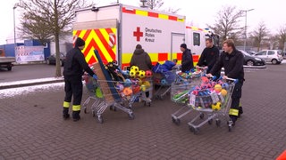 Das Deutsche Rote Kreuz hat mehrere volle Einkaufswagen mit Kinderspielzeugen. 