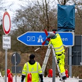 Ein rotes Kreuz wird über dem Autobahnschild der A27 angebracht. (Archivbild)