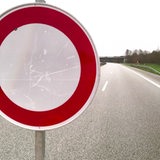 Es ist ein "Durchfahrt verboten"-Verkehrsschild vor einer leeren Autobahn zu sehen.