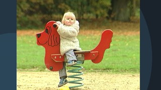 Ein Kind auf einer Schaukel auf dem Spielplatz.