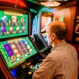 Ein Mann spielt in einer Spielhalle an einem Multigamerspielautomat