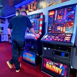 Ein Mann steht vor einem Automaten in einer Spielhalle
