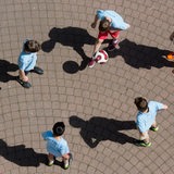 Schüler spielen Fußball auf einem Schulhof.