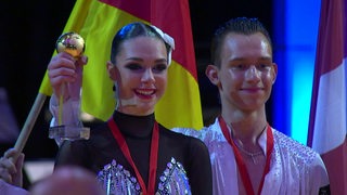 Luna Albanese und Dimitri Kalistov auf dem Treppchen der Siegerehrung als Weltmeister.
