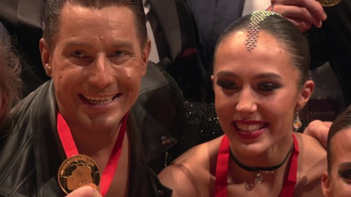 Tänzer Thomas Friedrich und seine Partnerin Noelia Boßmann-Otero zeigen ihre Goldmedaille. 
