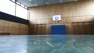Spuren sind auf dem Boden einer leeren Turnhalle zu sehen.
