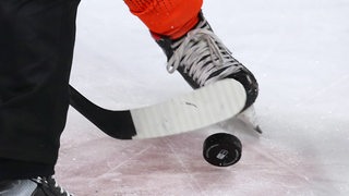 Close Up auf Eishockeyschläger, Puk und Schlittschuhen