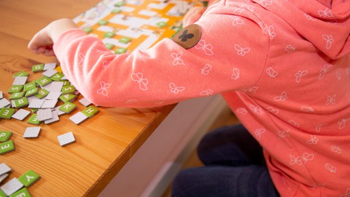 Ein Kind spielt mit Buchstabenkärtchen