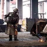 Stahlarbeiter schweißt Material in Schutzkleidung 