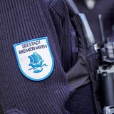 Die Nahaufnahme zeigt den Ärmel einer Person mit einem Emblem mit der Aufschrift "Seestadt Bremerhaven".