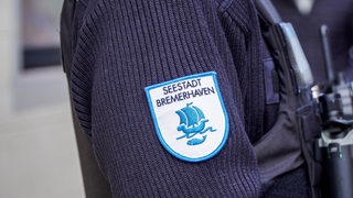 Die Nahaufnahme zeigt den Ärmel einer Person mit einem Emblem mit der Aufschrift "Seestadt Bremerhaven".