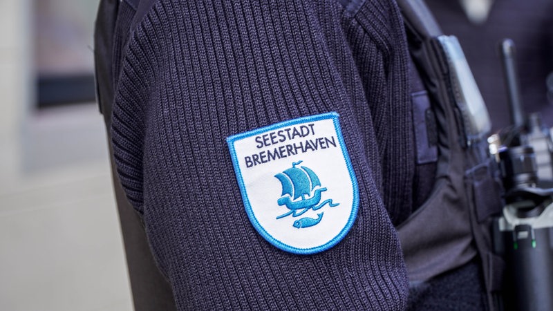 Die Nahaufnahme zeigt den Ärmel einer Person mit einem Emblem mit der Aufschrift "Seestadt Bremerhaven".