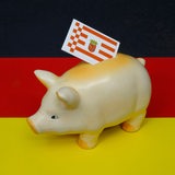 Auf einer Deutschlandfahne steht ein Sparschwein mit dem Landeswappen von Bremen.