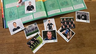 Ein aufgeklapptes Stickeralbum mit Bildern von Schiedsrichtern der Bundesliga.