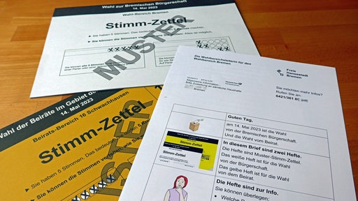 Die Stimmzettel für die Bremische Bürgerschaftswahl liegen ausgebreitet auf einem Tisch.