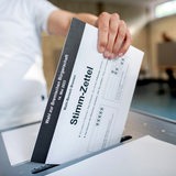 Ein Bürger wirft in einem Wahllokal seinen Stimmzettel für die Bürgerschaftswahl in eine Wahlurne