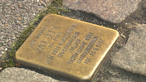 Ein Stolperstein in einer Pflasterung.