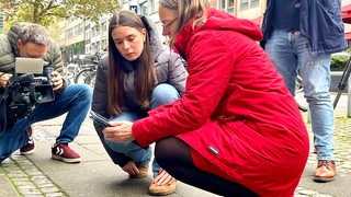 Eine Schülerin zeigt Sascha Aulepp die Funktionsweise der App für die Stolpersteine in Bremen